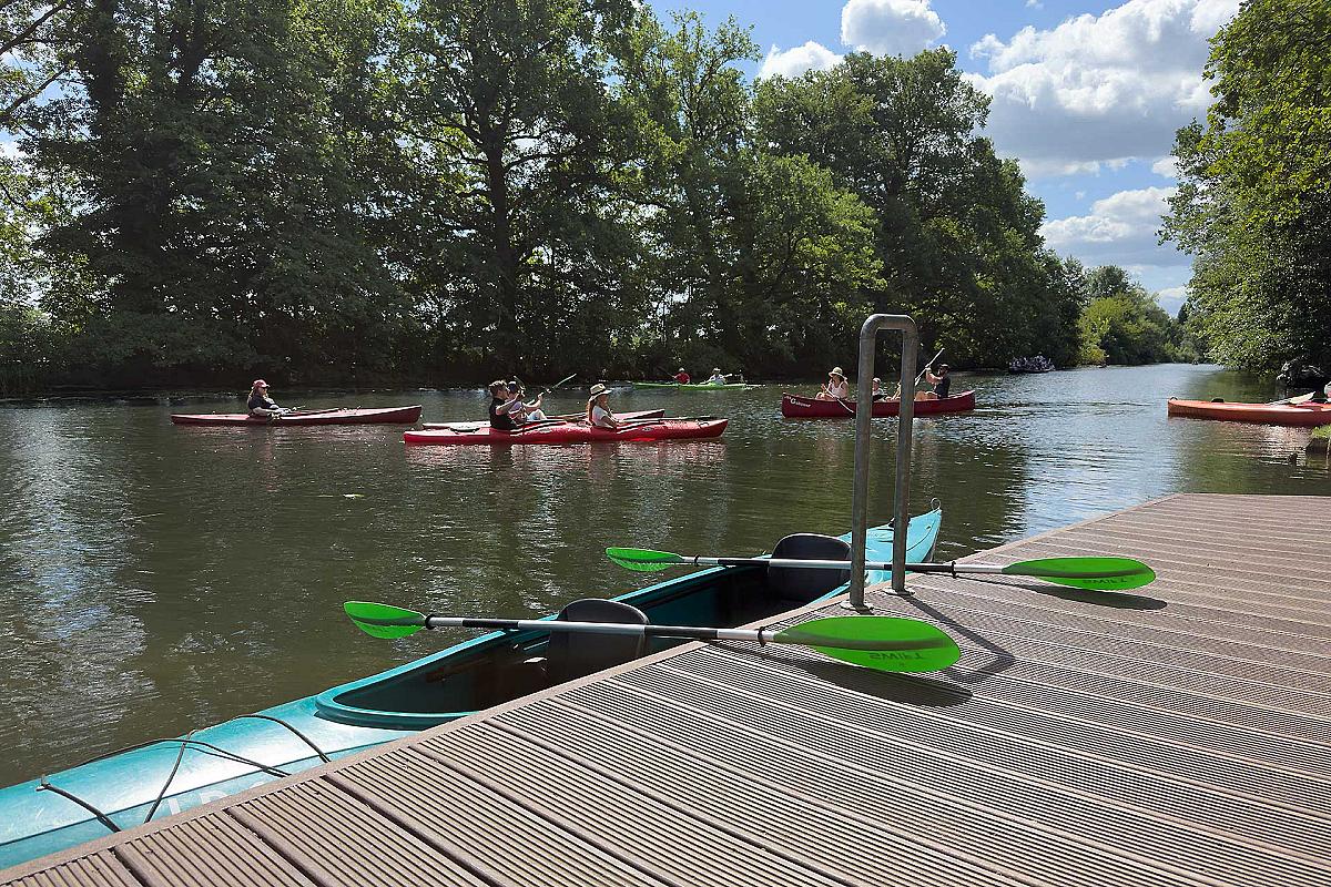 Gasthaus Lehnigksberg - Ein grünes 2er Kajak liegt im Wasser. Quer zum Boot 2 Doppelpaddel.