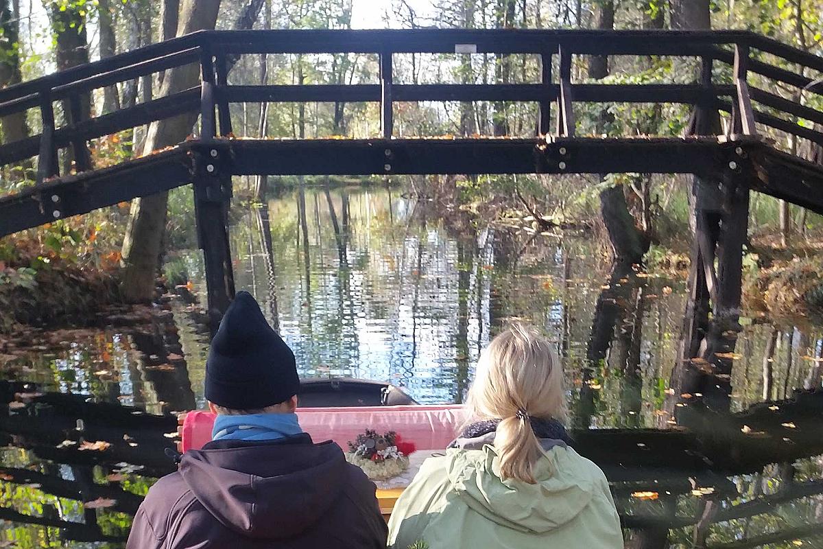 Kahngenuss Spreewaldkahnfahrten - Glühweinkahnfahrt unter einer Holzbrücke hindurch